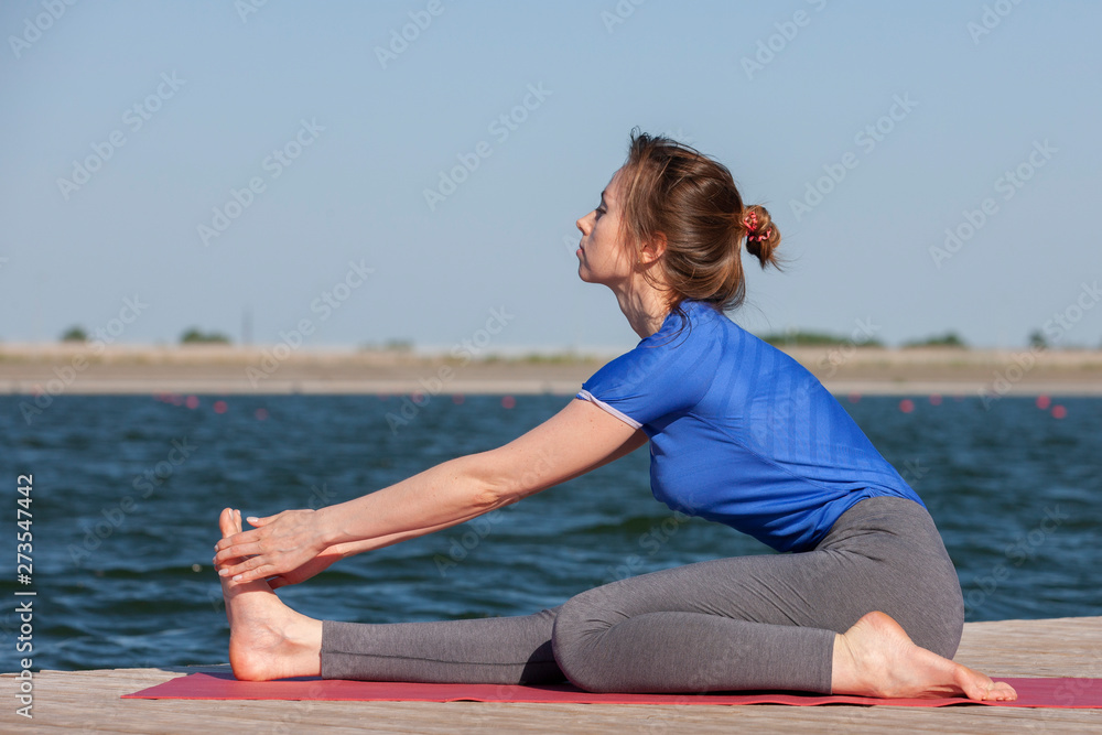 The girl is engaged in meditation on coast of lake