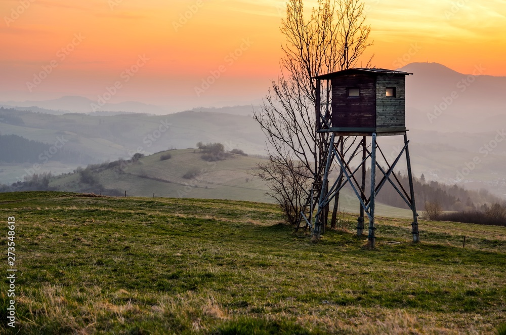 Beautiful mountain colorful landscape. Hunting pulpit and the setting sun over the hills.