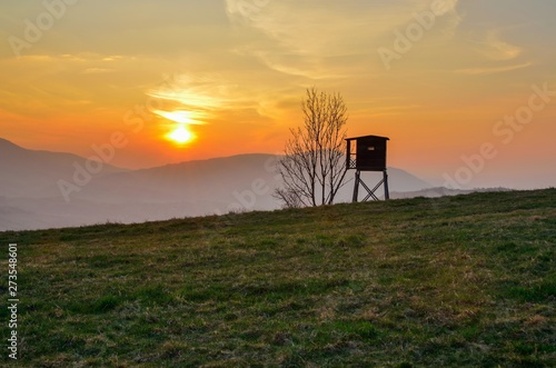 Beautiful mountain colorful landscape. Hunting pulpit and the setting sun over the hills.
