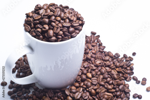 White cup with coffee beans on white