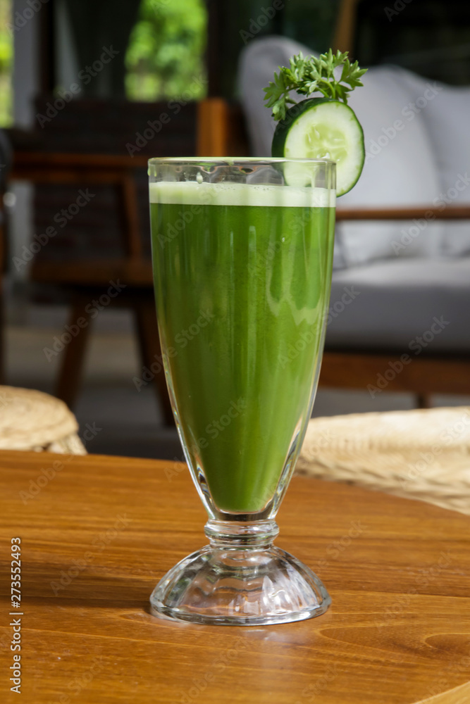 Fresh organic green smoothie in the glass on the table, healthy summer day refreshment Fresh organic green smoothie in the glass on the table, healthy summer day refreshment