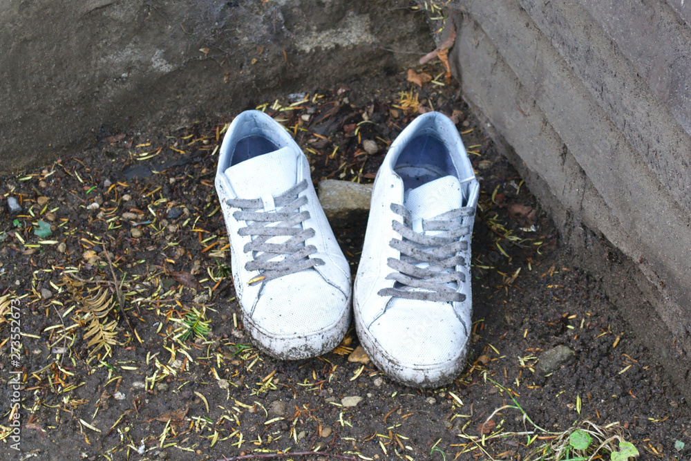 Sneakers thrown out the street. The poverty concept. Environmental pollution. Waste management.