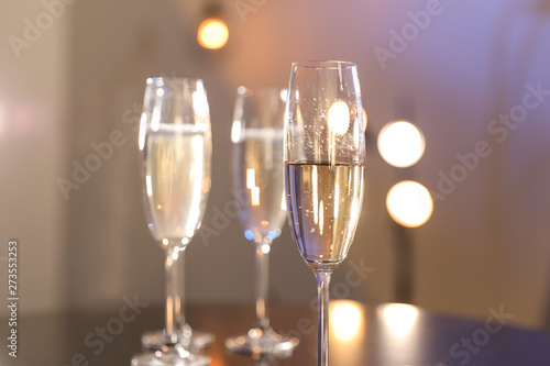 Glasses of champagne on blurred background, closeup. Space for text