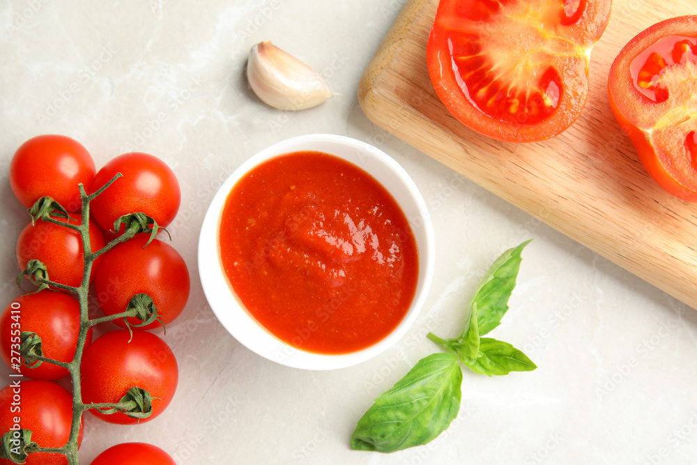 Flat lay composition with bowl of sauce and tomatoes on light table Flat lay composition with bowl of sauce and tomatoes on light table