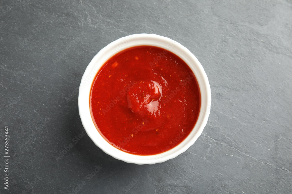 Bowl of tasty tomato sauce on grey table, top view Bowl of tasty tomato sauce on grey table, top view