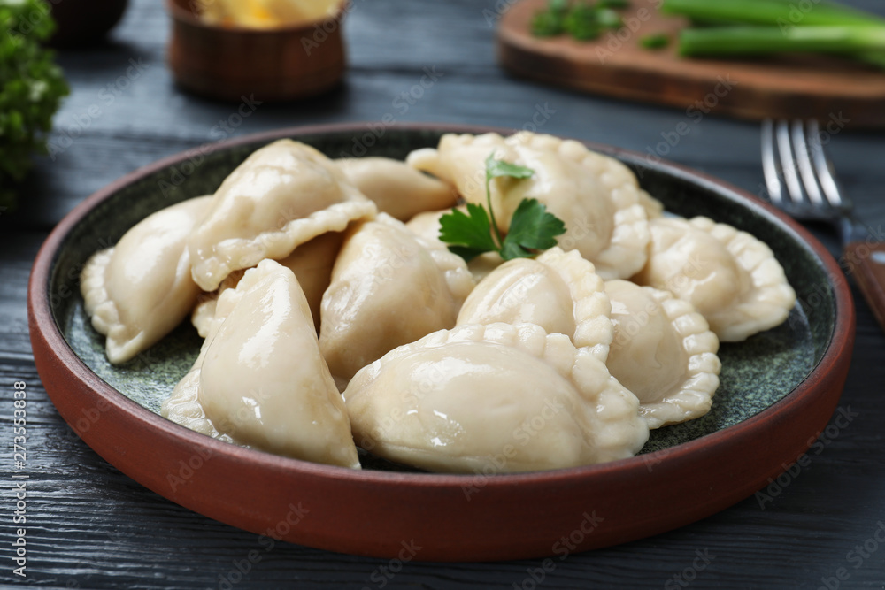 Plate of tasty dumplings served with parsley on table Plate of tasty dumplings served with parsley on table
