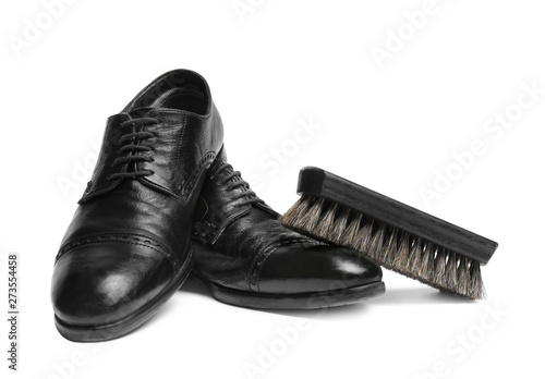 Stylish men's shoes and cleaning brush on white background
