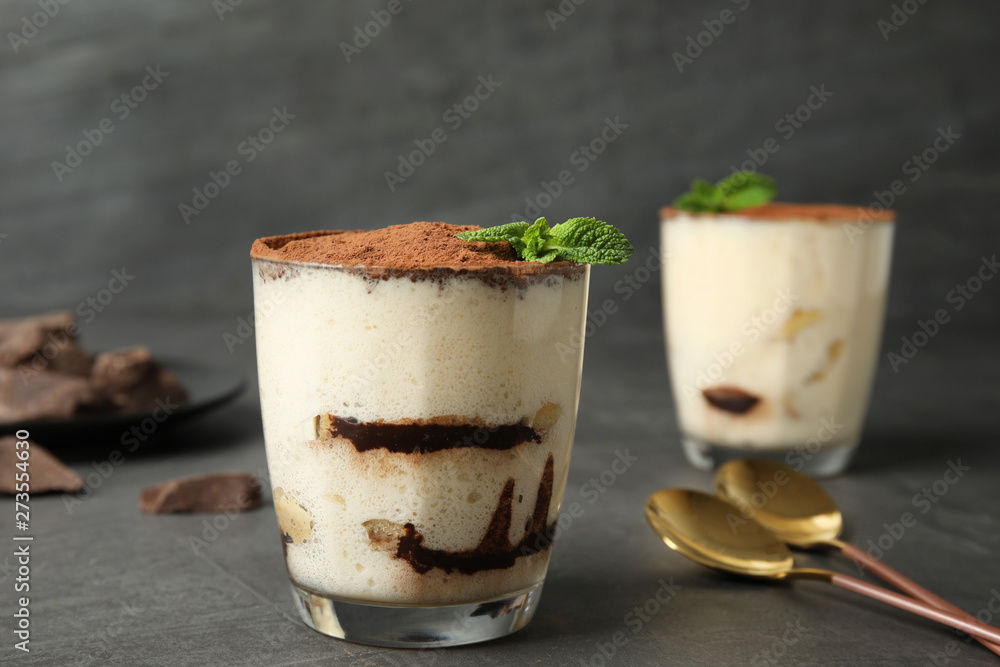 Delicious tiramisu cake in glass on table Delicious tiramisu cake in glass on table