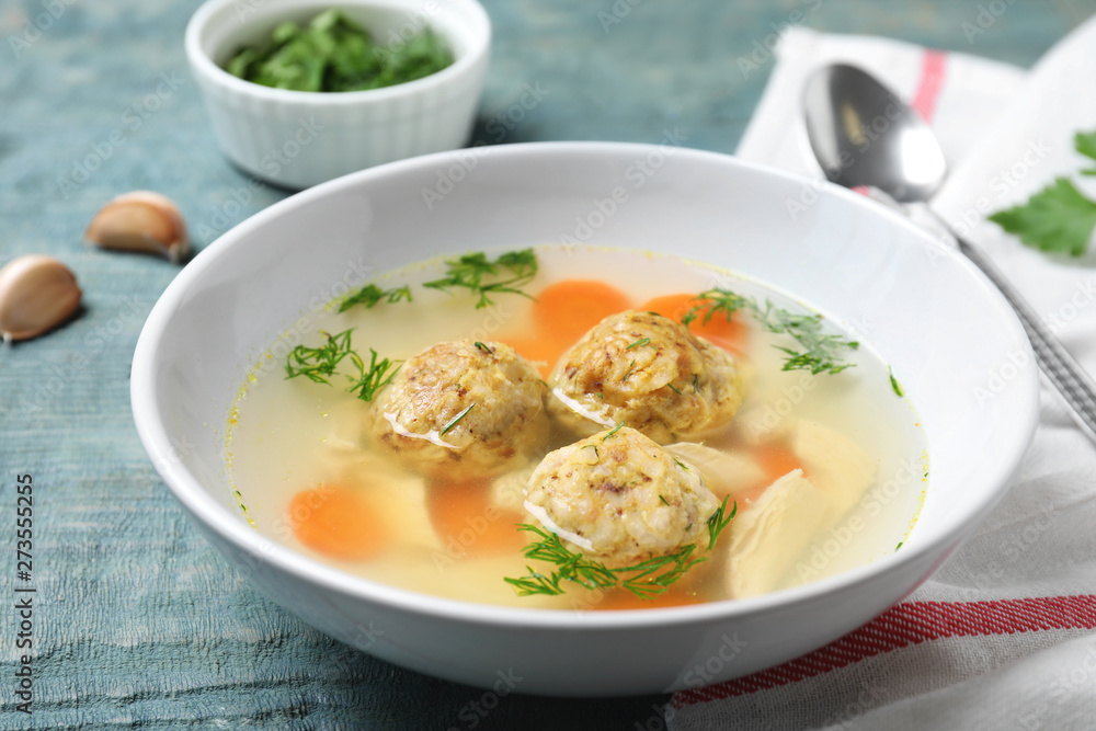 Bowl of Jewish matzoh balls soup on color wooden table Bowl of Jewish matzoh balls soup on color wooden table