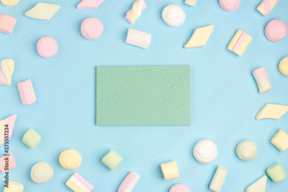 Blue background with marshmallow and blank notepad. Place for your text. Cozy sweet background Blue background with marshmallow and blank notepad. Place for your text. Cozy sweet background