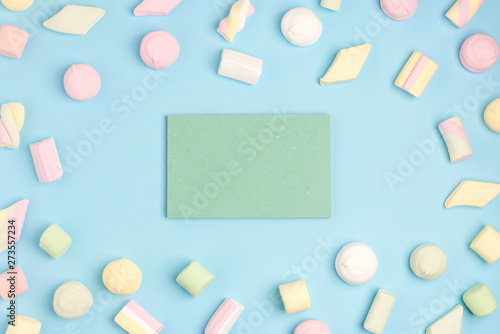 Blue background with marshmallow and blank notepad. Place for your text. Cozy sweet background