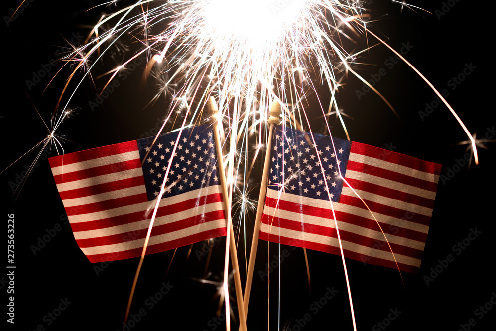 Lit sparkler over two American Flags for 4th of July celebration Stock ...