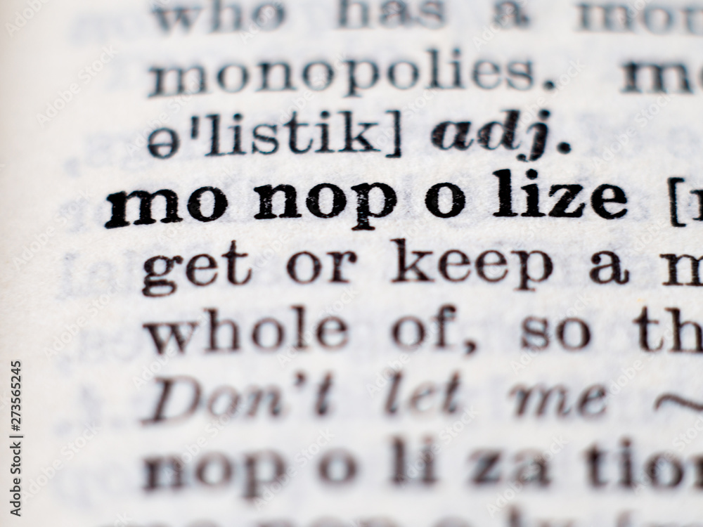 Dictionary definition of word monopolize. Selective focus. Dictionary definition of word monopolize. Selective focus.