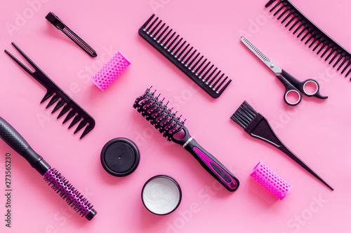 Fototapeta Naklejka Na Ścianę i Meble -  professional accessories of hairdresser with combs and sciccors on work desk pink background top view copyspace