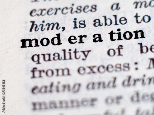 Dictionary definition of word moderation. Selective focus.