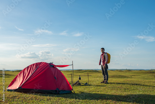the tourist With backpack With tent accommodation in the lawn