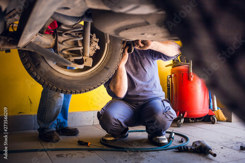 Photo of car mechanics fixing the car. Inside the car shop. photo