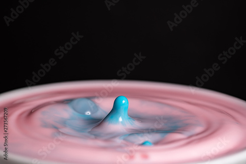 Splash of milk droplets in close up macro high resolution isolated against a black background