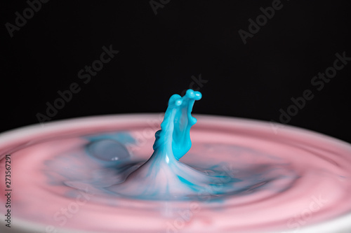 Splash of milk droplets in close up macro high resolution isolated against a black background