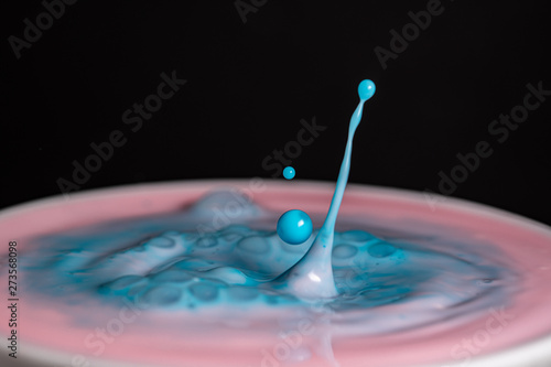 Splash of milk droplets in close up macro high resolution isolated against a black background