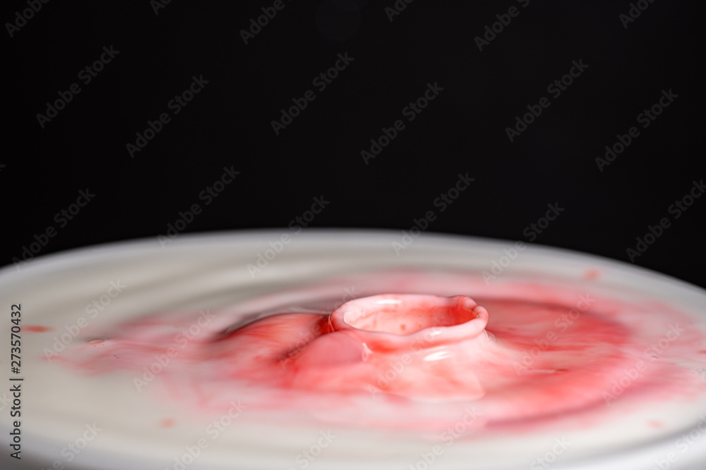 Splash of milk droplets in close up macro high resolution isolated against a black background Splash of milk droplets in close up macro high resolution isolated against a black background