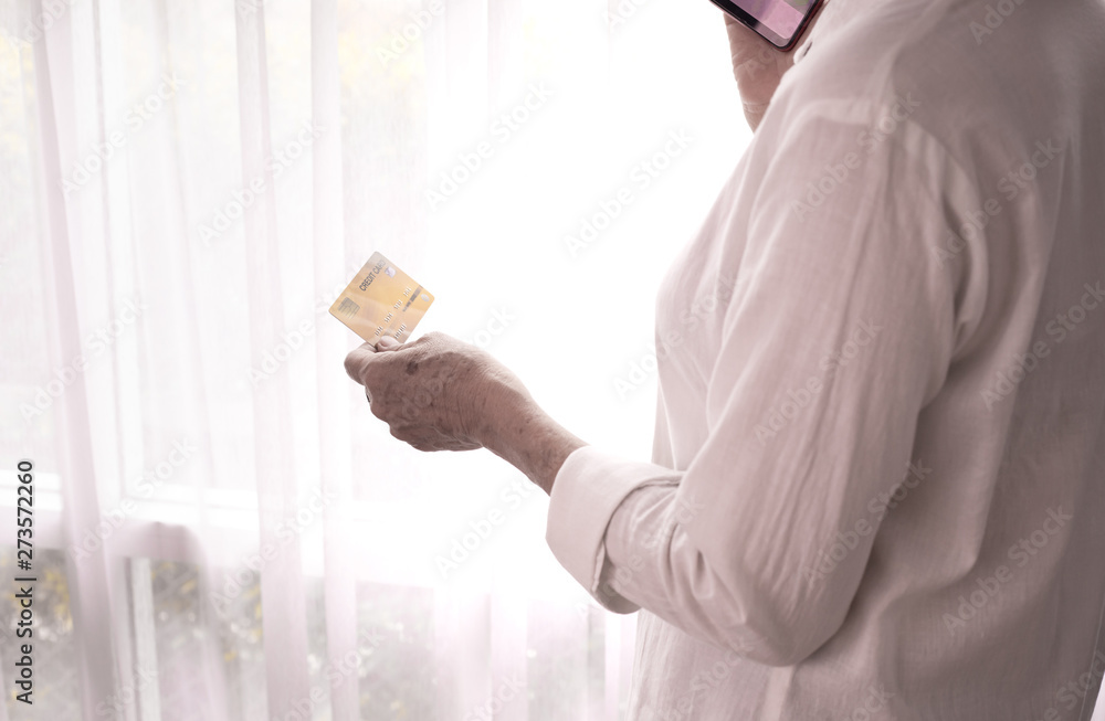 businesswoman hold credit card and using phone on white curtain window background.