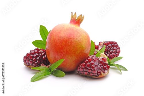 Pomegranate whole and cut with green leaves isolated on white background. Pomegranates (Punica granatum) is a fruit-bearing deciduous shrub in the family Lythraceae. Pomegranate fresh fruit Isolated.