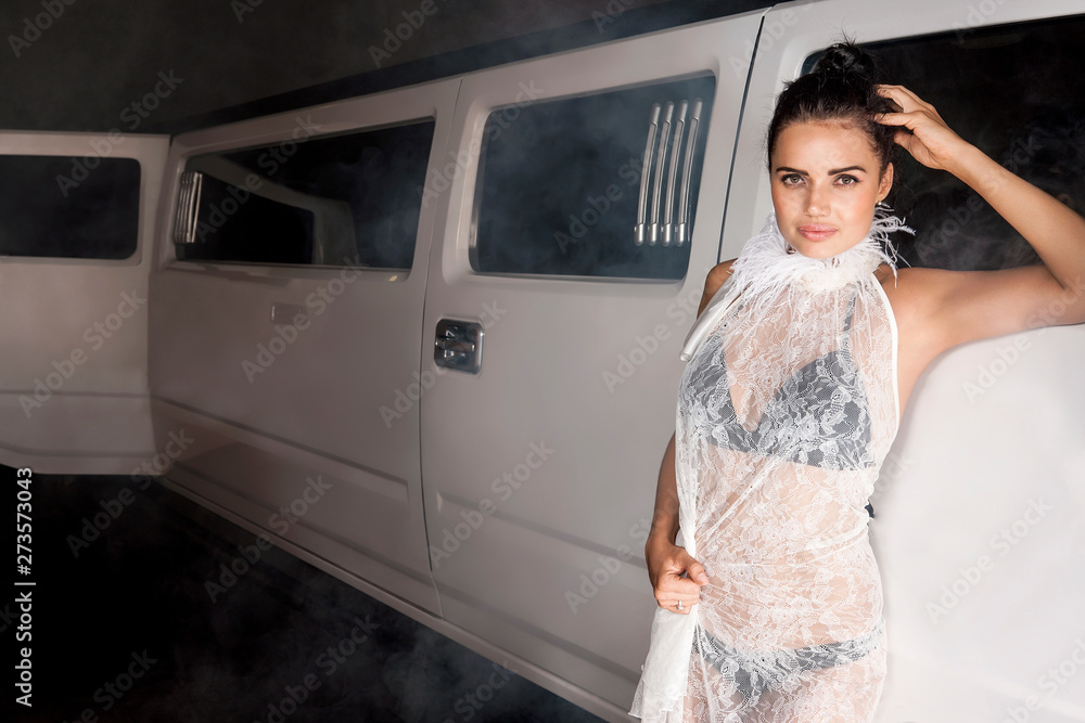 Girl in a transparent dress standing next to a vehicle Girl in a transparent dress standing next to a vehicle