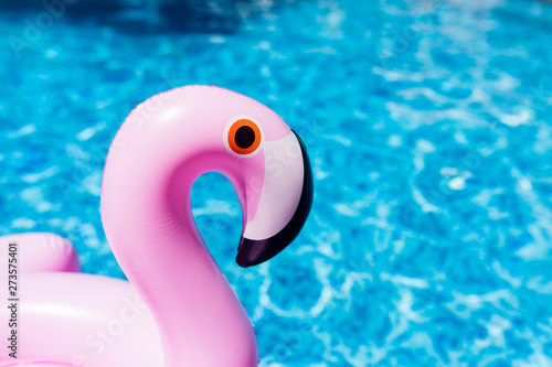 Inflatable pink flamingo at the swimming pool. Summer time in the swimming pool with plastic toys. Relaxation, holiday, vacation and fun concept © Алина Бузунова