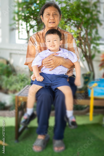 Little Asian boy sit with grandmother