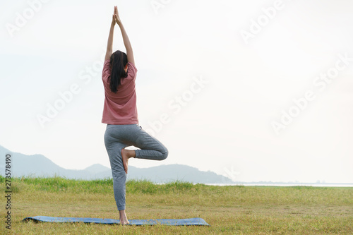 Asian young woman exercise and practice yoga in the relax nature background.