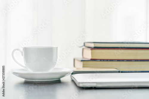 Coffee cup and book on table