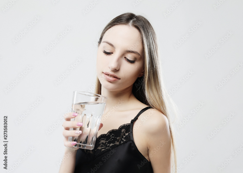 lifestyle, health and people concept - young woman wearing pajamas holding water glass lifestyle, health and people concept - young woman wearing pajamas holding water glass