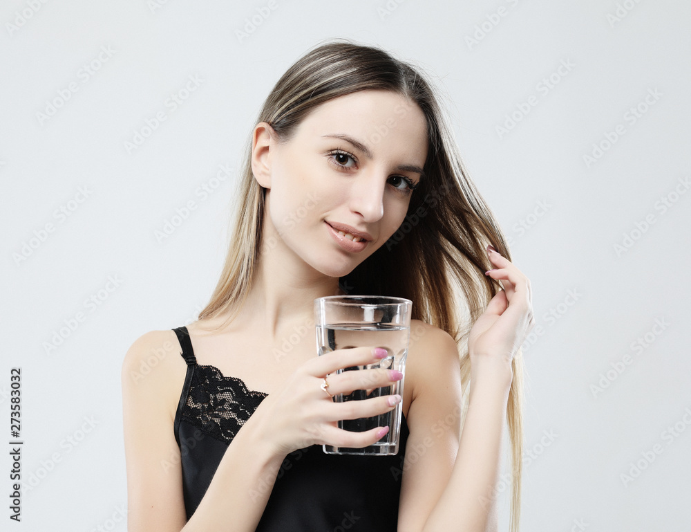 lifestyle, health and people concept - young woman wearing pajamas holding water glass lifestyle, health and people concept - young woman wearing pajamas holding water glass
