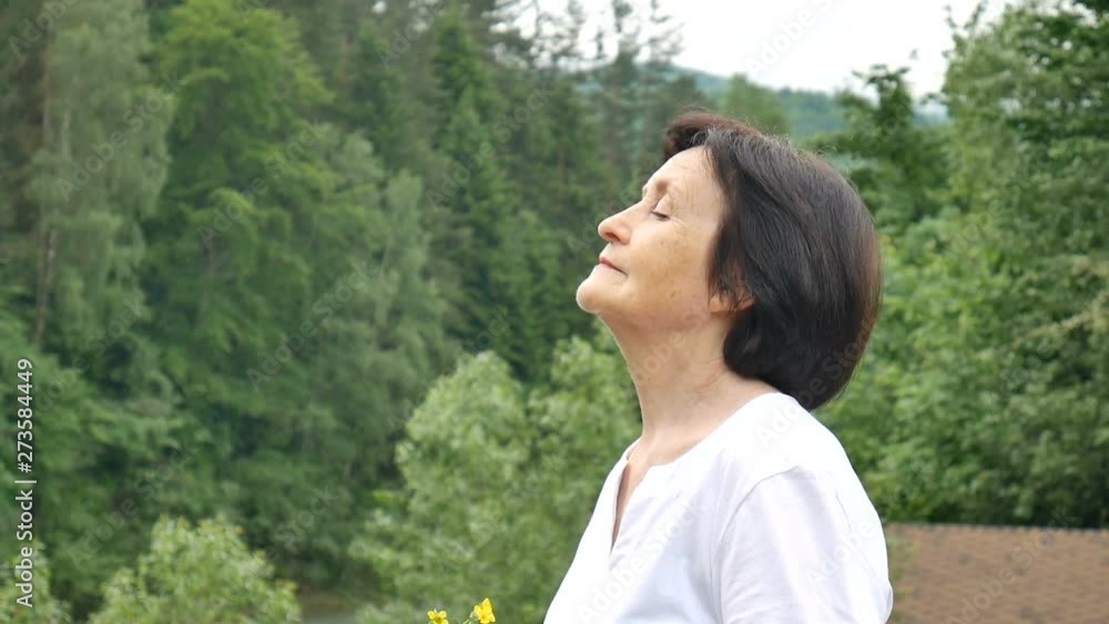 Portrait of a happy relaxed pensioner on vacation in the mountains. Fresh mountain air, travel concept, Mother's Day Portrait of a happy relaxed pensioner on vacation in the mountains. Fresh mountain air, travel concept, Mother's Day