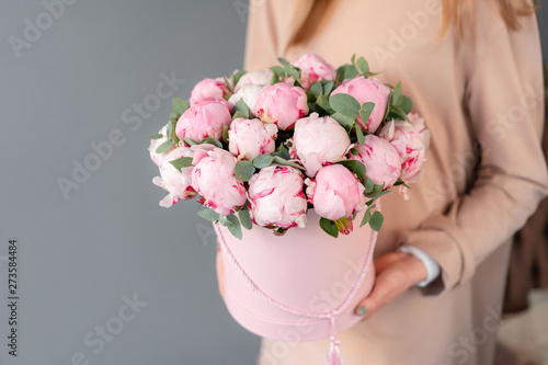 Fototapeta Naklejka Na Ścianę i Meble -  Pink peonies in pink round box. Beautiful peony flower in womans hands for catalog or online store. Floral shop concept. Flowers delivery. copy space