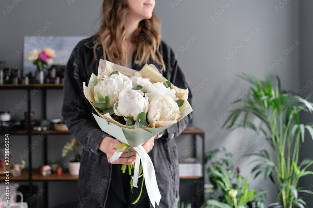 Fototapeta premium White peonies in womans hands. Beautiful fresh peony flower for catalog or online store. Floral shop concept. Flowers delivery