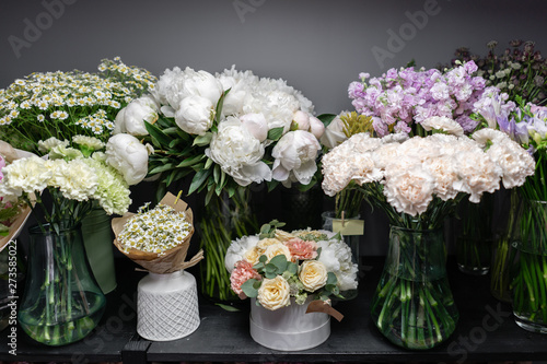Vases with different colored flowers, showcase flower shop. Beautiful spring bouquets. . Small family business. Work florist. copy space