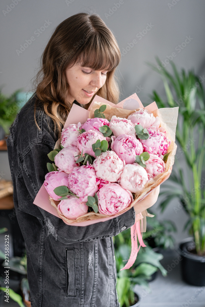 Pink peonies in womans hands. Beautiful peony flower for catalog or online store. Floral shop concept . Beautiful fresh cut bouquet. Flowers delivery