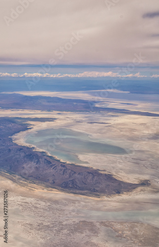 Aerial view from airplane of the Great Salt Lake in Rocky Mountain Range, sweeping cloudscape and landscape during day time in Spring. In Utah, United States.