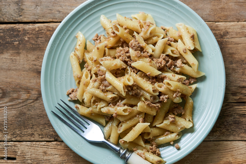 Penne pasta with minced meat on a blue plate Penne pasta with minced meat on a blue plate