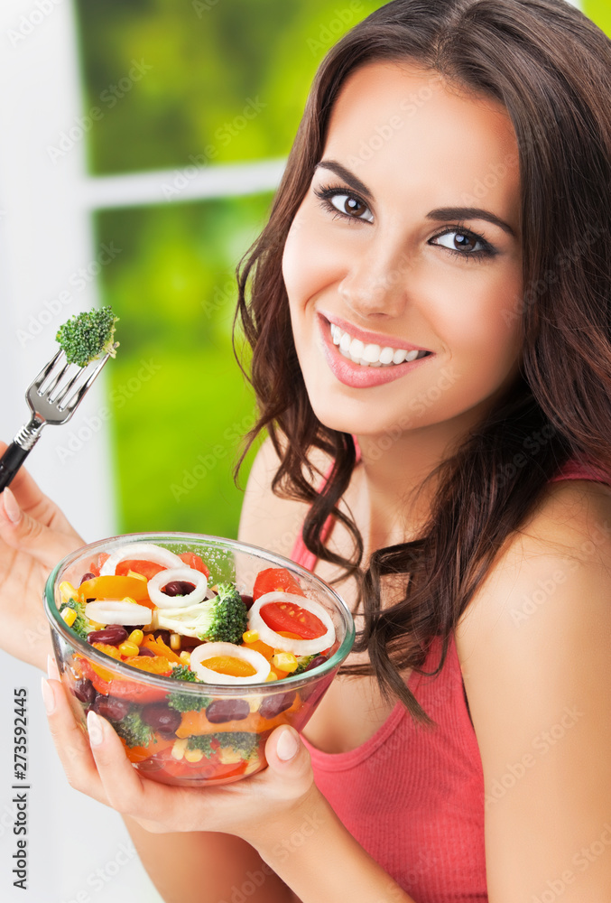 Portrait picture of happy woman eating salad, outdoor