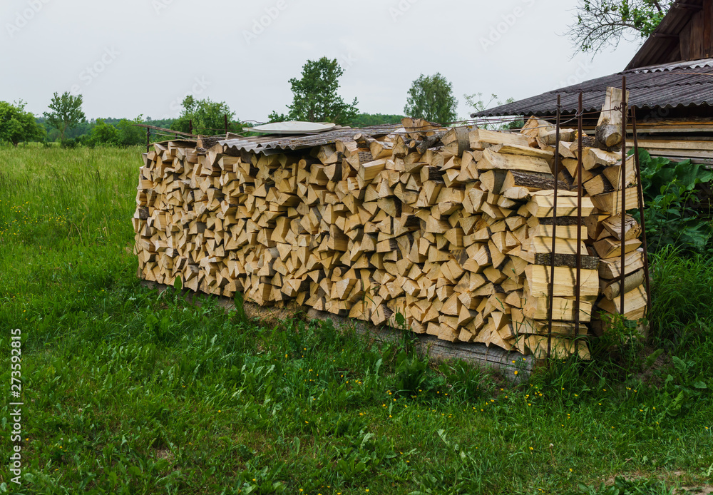 Fuel for stove heating at home and bath. Rural life. Wooden firewood is laid in the walls. Natural wood.