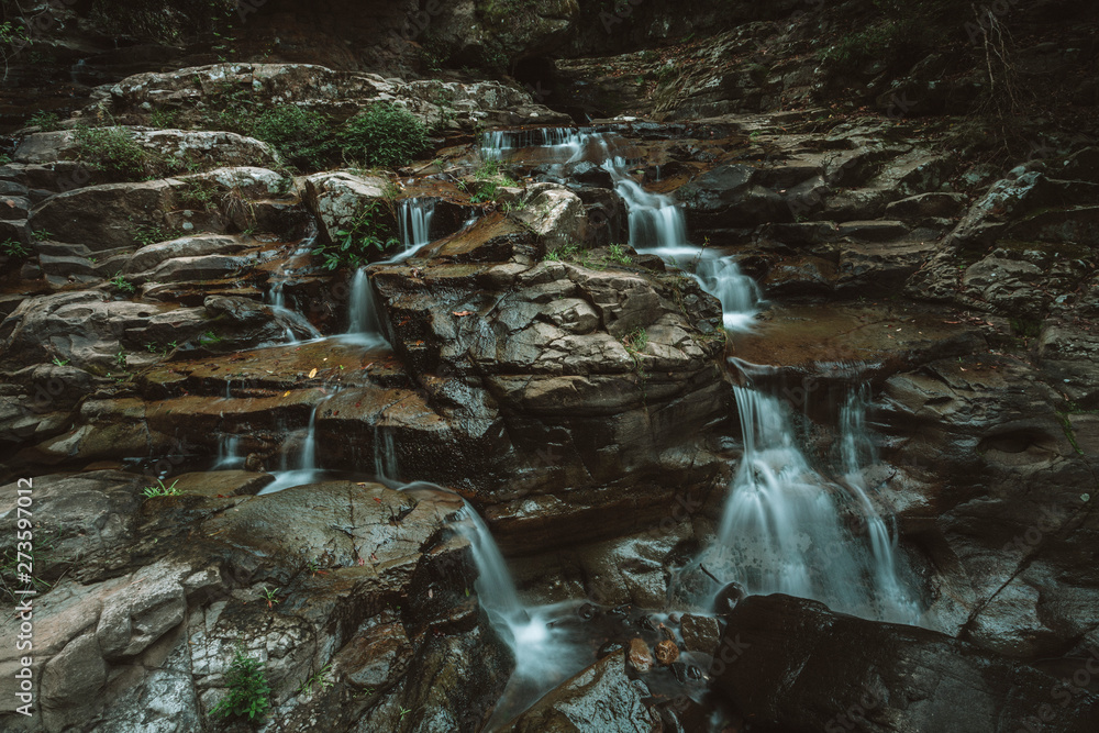 Obraz premium Running stream cascades over rocks waterfalls in Macquarie Pass wilderness of Australia