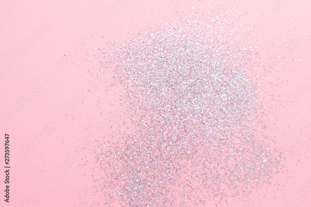 Silver sparkles on a pastel pink background. Stylish abstract minimalistic image.