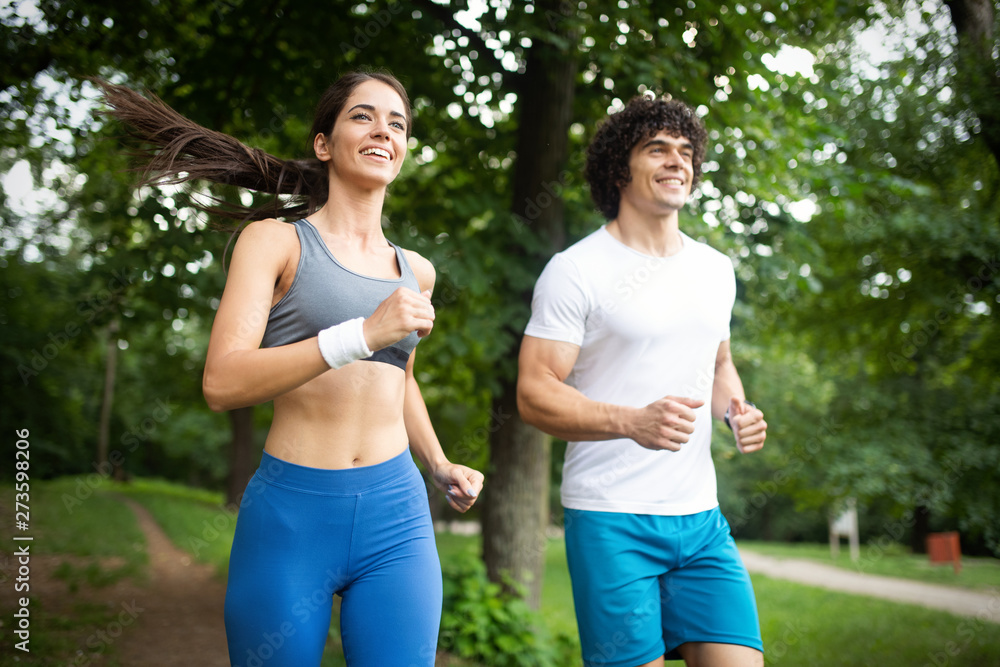 Fototapeta premium Happy young woman doing excercise outdoor in a park, jogging