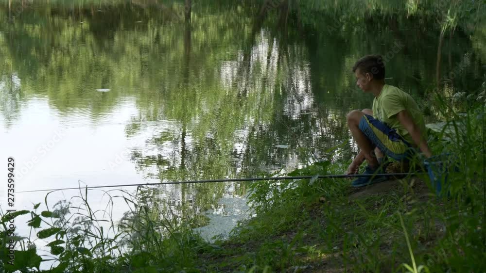teen child catches a fishing rod on the pond. teen child catches a fishing rod on the pond.