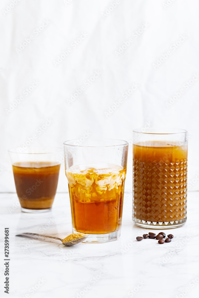 Iced coffee with cream and vanilla in various glasses on white background. Summer cocktail or dessert Iced coffee with cream and vanilla in various glasses on white background. Summer cocktail or dessert