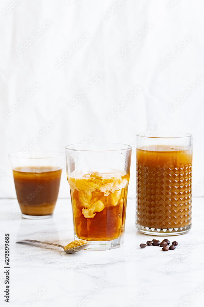 Iced coffee with cream and vanilla in various glasses on white background. Summer cocktail or dessert Iced coffee with cream and vanilla in various glasses on white background. Summer cocktail or dessert