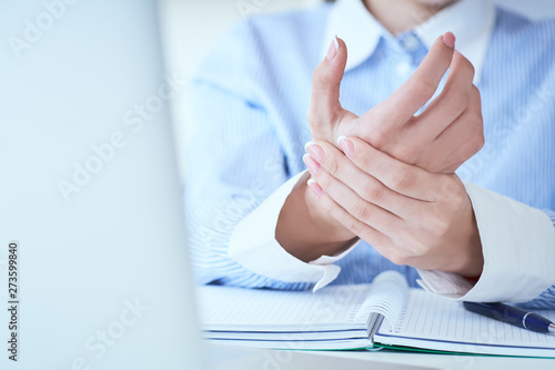 Young woman holding her wrist close-up . Pain from using computer. Office syndrome hand pain by occupational disease. © cameravit
